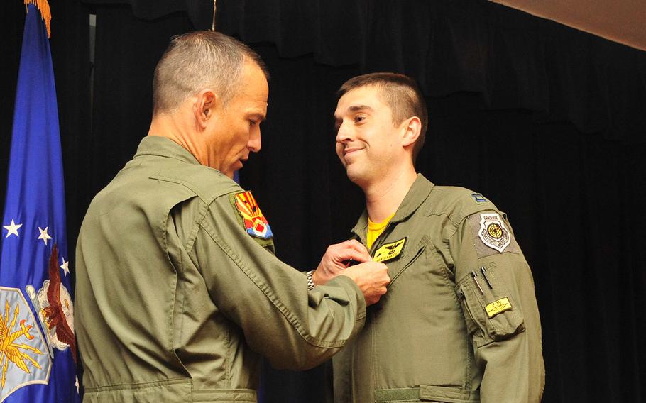 Brig. Gen. Scott Pleus, 56th Fighter Wing commander, pins the Air Force Combat Action Medal onto Capt. Aaron Cavazos, 61st Fighter Squadron weapons officer, Jan. 16 in Club Five Six at Luke Air Force Base. Cavazos was awarded the Air Force Combat Action Medal and the Distinguished Flying Cross with Valor for his heroism while serving in Operation Enduring Freedom Oct. 28, 2008. Cavazos efforts saved the lives of six Marines that day.