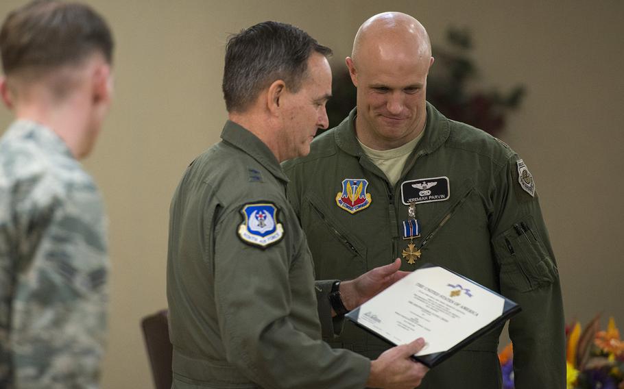 U.S. Air Force Maj. Jeremiah Parvin, 75th Fighter Squadron A-10C Thunderbolt II pilot, smiles as Maj. Gen H.D. Polumbo Jr., Ninth Air Force commander, presents a certificate during a Distinguished Flying Cross presentation ceremony Jan. 29, 2015, at Moody Air Force Base, Ga. Parvin earned the Distinguished Flying Cross with Valor for his actions in Afghanistan in 2008 and is credited with saving the lives of six Marines.