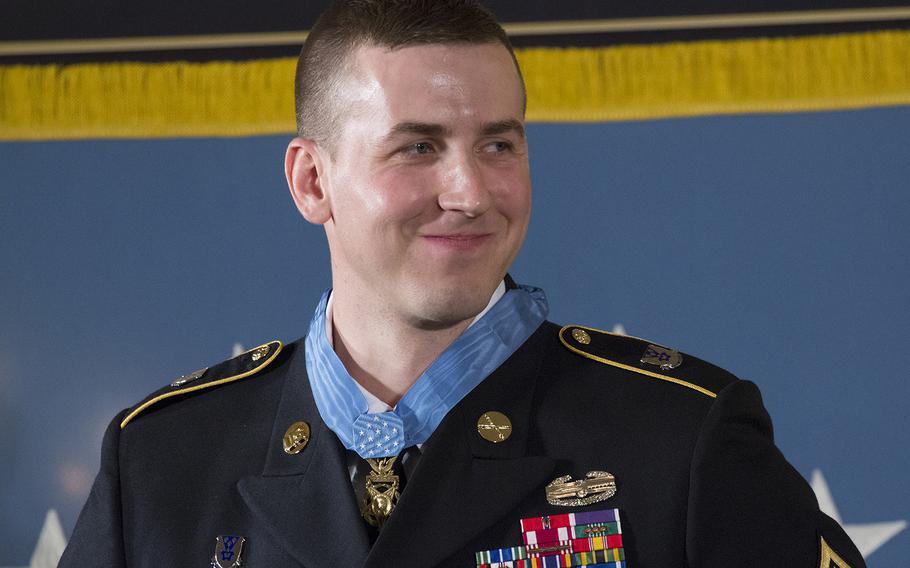 Former Army Staff Sgt. Ryan Pitts smiles as President Barack Obama speaks during the Medal of Honor ceremony at the White House, July 21, 2014.
