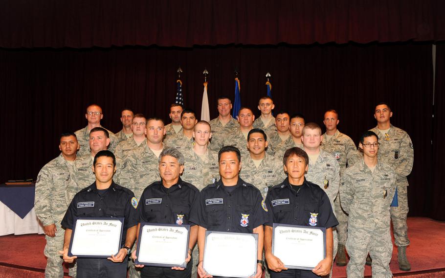 U.S. military and Japanese civilian first responders stand for a group photo after receiving Air Force Commendation medals, Air Force Achievement medals or outstanding achievement awards from U.S. Air Force Brig. Gen. James Hecker, 18th Wing commander, on Sept. 12, 2014. The group was responsible for rescuing two trapped airmen from a flooding guard shack during typhoon Neoguri on July 9, 2014.