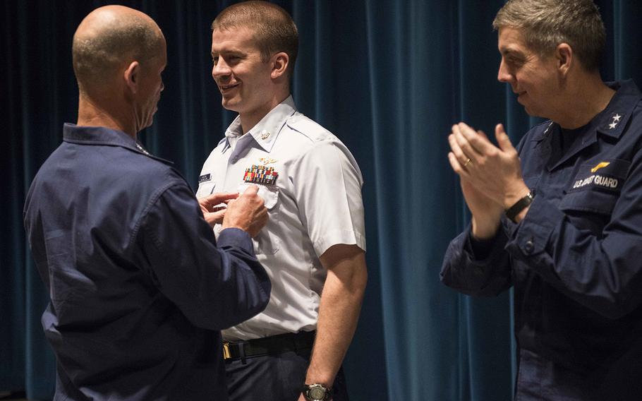Pacific Area Commander Vice Adm. Charles W. Ray and 17th District Commander Rear Adm. Daniel Abel present an award to Petty Officer 2nd Class Jonathan Kreske at Coast Guard Base Kodiak, Alaska, Feb. 18, 2015. Kreske, a rescue swimmer at Coast Guard Air Station Kodiak, was awarded the National Society Daughters of the American Revolution Medal of Honor for his outstanding service and leadership to his community, state and nation.