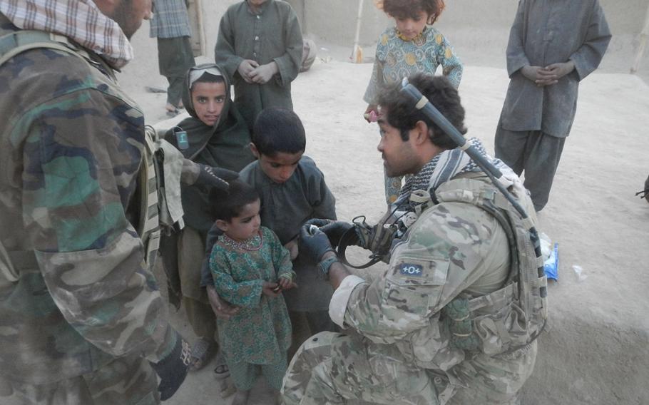 Master Sgt. Ivan Ruiz treats a girl's infected eye in Afghanistan in October, 2013.