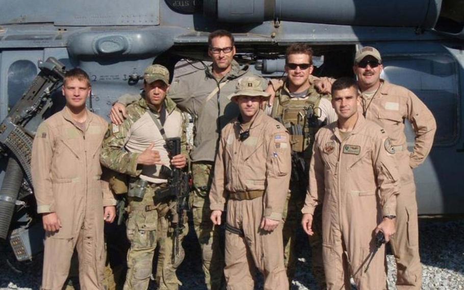 At 6-foot-8, Master Sgt. Roger Sparks towers over the team of pararescue jumpers and pilots he worked with during deployment to Afghanistan in 2010. His right arm is around Capt. Koaalii Bailey, who was on the ground with Sparks on Nov. 14, 2010.