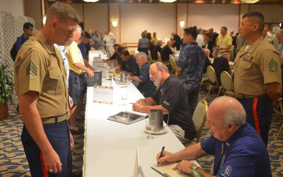 Medal of Honor recipient James Taylor signs a book for a Marine sergeant during an event at the Hale Koa Hotel in Honolulu on Oct. 6, 2012. The signing was the final public event of the 2012 Medal of Honor Convention. The reunion of 52 medal recipients is thought by organizers to be the largest ever gathering of its kind.
