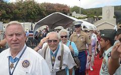 Vietnam-era Medal of Honor recipient George "Bud" Day, center, salutes as he walks down a red carpet at the National Cemetery of the Pacific in Honolulu on Oct. 3, 2012. Day and 51 other Medal of Honor recipients -- more than anyone present could remember gathering in one place -- honored past medal recipients buried at the cemetery with a stone memorial dedication.
