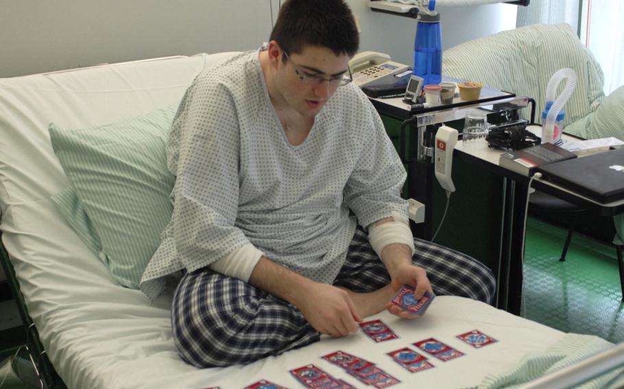 Sean Ballard, a senior at AFNORTH High School, plays cards in his room at Germany's University Hospital Aachen on May 10.  The next day, Ballard underwent surgery during which doctors placed titanium rods to curtail the curving of his spine.  Ballard was diagnosed with Scheuermann's Juvenile Kyphosis in the seventh grade, which sometimes can cause the spine to curve forward resulting in a severe hunchback.