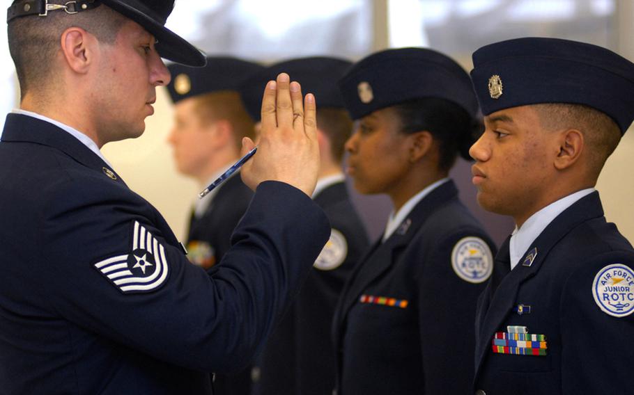 Marco Gonzalez, a graduating senior from SHAPE High School in Belgium, gets a lesson on wearing the flight cap from Tech. Sgt. Jacob Chavez during an inspection in March at Kaiserslautern High School.  Chavez, an airmen assigned to the 86th Aircraft Maintenance Squadron, was a military training instructor.