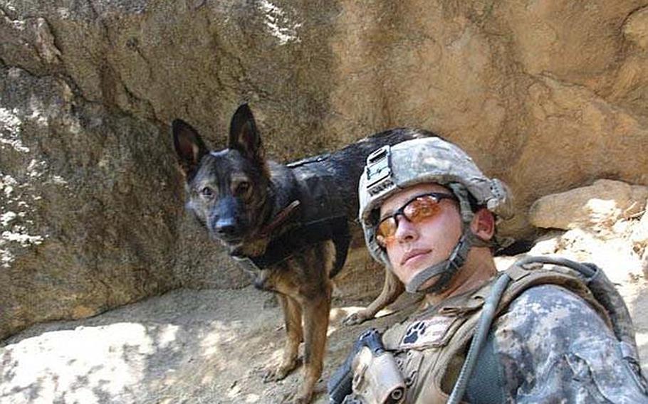 Petty Officer 1st Class Rueben Davis and his military working dog, Alva, take a rest near the village of Chapadara, where a battle unfolded during a 2009 deployment in eastern Afghanistan.