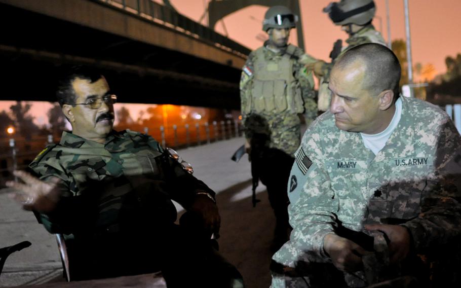 Iraqi army Lt. Col. Abadi Mashkoor Sultan, commander of 1st Battalion, 56th Baghdad Brigade, left, talks to Lt. Col. Gregory McVay, security director for the 72nd Joint Area Support Group-Central, about security issues in the International Zone in Baghdad. The evening meeting took place on the 14th of July Bridge over the Tigris river. McVay meets Abadi, who commands all Iraqi army troops in the International Zone, regularly.