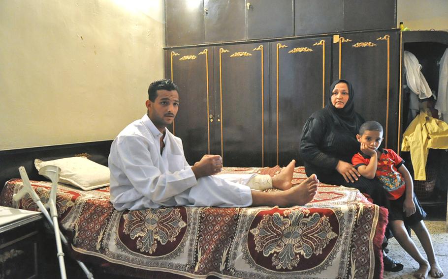 Fadel Nathem, was the equivalent of a specialist when he was wounded by a suicide car bomber in Sept. 2008. With him in the room where he lives is his mother Yasra Abd Ali, his main caretaker, and his youngest brother.