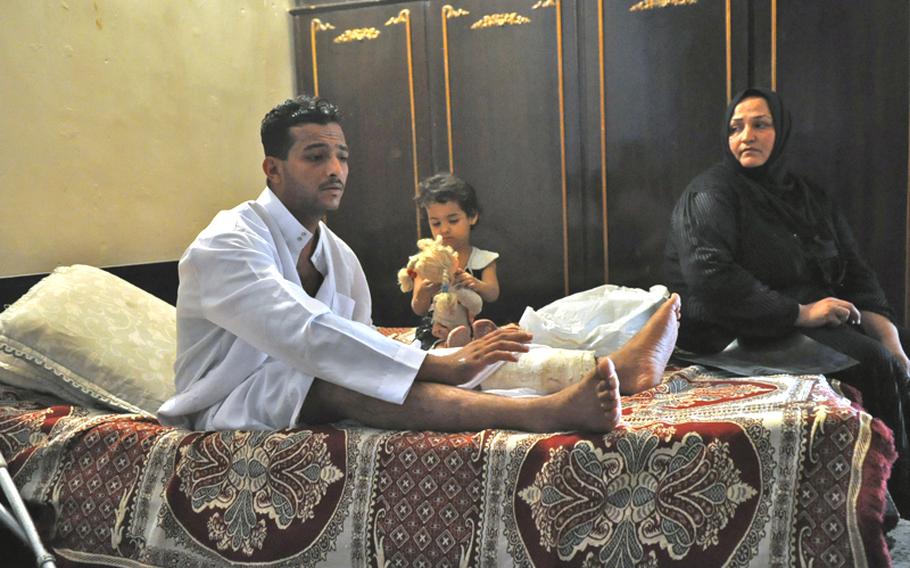 Fadel Nathem was the equivalent of a specialist when he was wounded by a suicide car bomber in Sept. 2008. At center is his four year old daughter Mariam, at right is Fadal&#39;s mother Yasra Abd Ali, his main caretaker.