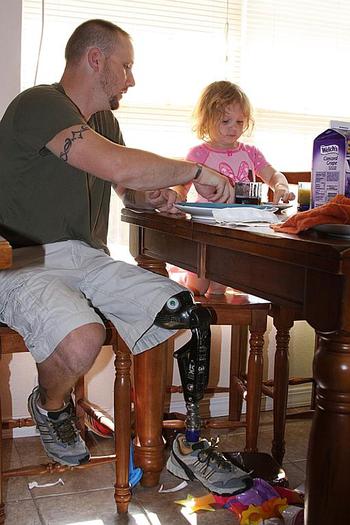 Bobby Lisek shares breakfast with his three-year-old daughter, Gracie, at their home outside Springfield, Mo. Lisek lost his leg and suffered severe brain trauma in a September 2004 roadside bomb attack in Sadr City, Iraq, while he was serving as a U.S. soldier there.