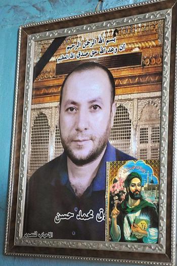 A photo of Saduk Mohammed Hassan, Aklas Farhood's late husband, hangs in the room she shares with her two sons in the Sadriya neighborhood of Baghdad. He was killed in a bombing while at working at his shop. A picture of Ali, the prophet Mohammed's son-in-law, a Shiite martyr, is in the lower right corner.