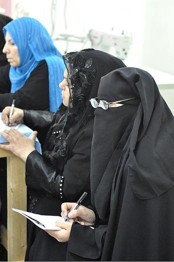 Women take notes during a sewing class at the Development and Training Widows Center in Baghdad.