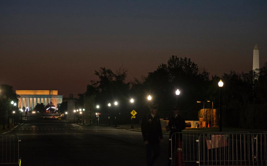 Two guards stand near the entrance of Arlington National Cemetery on May 4, 2015, as visitors wait for special access to the cemetery for a sunrise photo shoot. 