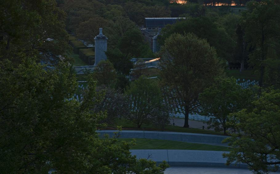 President John F. Kennedy's eternal flame on his grave in Arlington National Cemetery is seen as the sun starts to rise over Washington, D.C., on May 4, 2014.