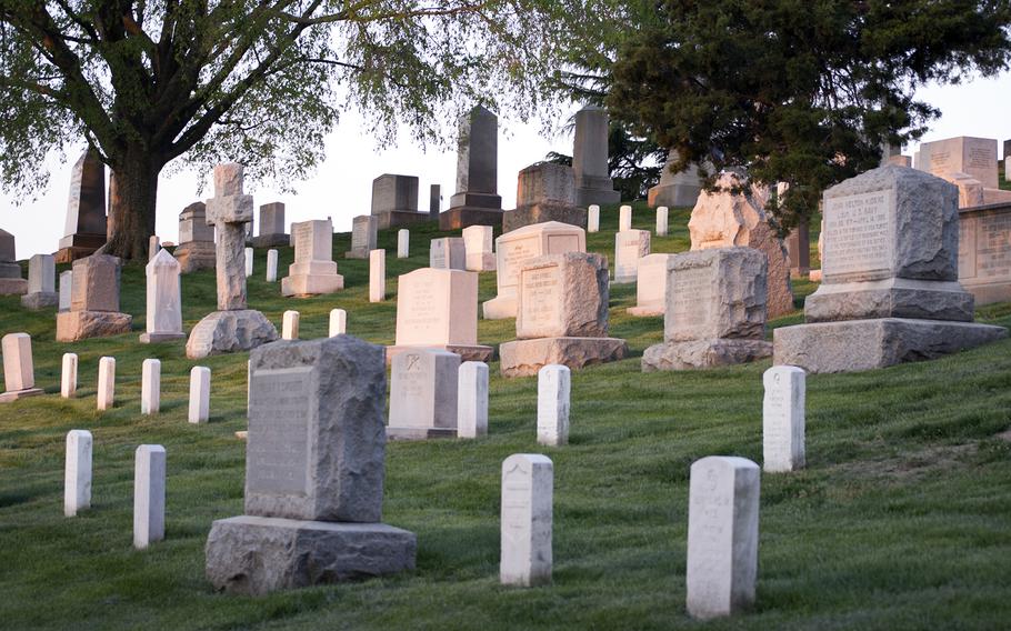 Grave stones at Arlington National Cemetery are cast in pink light as the sunrises on May 4, 2014.