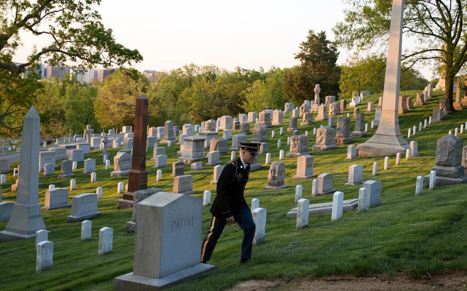 A servicemember walks through Arlington National Cemetery shortly after sunrise on May 4, 2014.