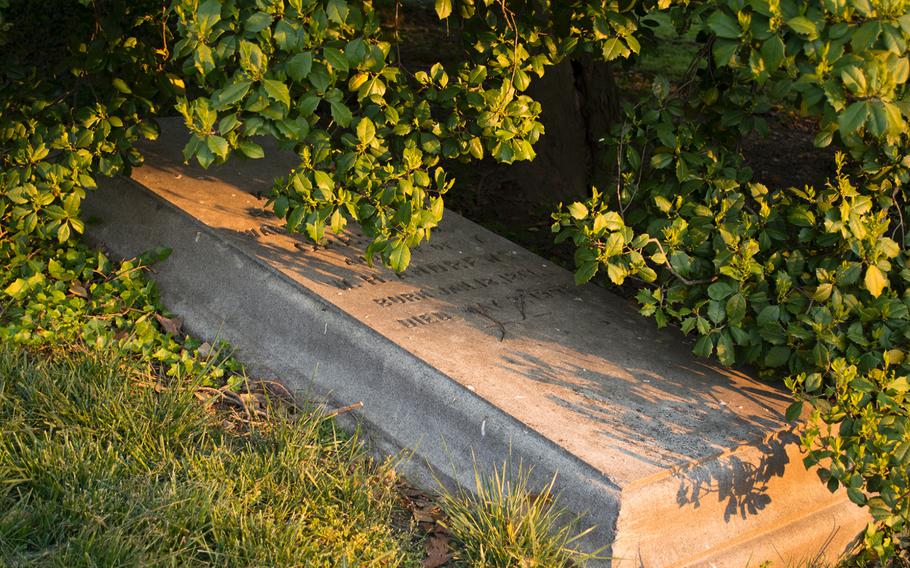 A grave marker is cast in pinks and shadows near the Arlington House on May 4, 2014, shortly after sunrise. 