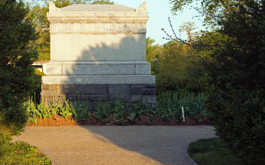 A grave near the flower garden at the Arlington House is cast in shadows and early sun on May 4, 2014.