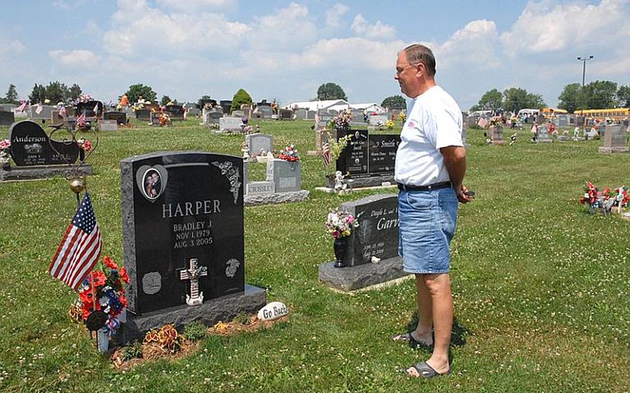 Steve Harper stands at the grave of his son Brad Harper, who was killed in Iraq in 2005. The cemetery in Dresden, Ohio, just north of Zanesville, overlooks the football field where Brad played in high school. The school has his away jersey framed in the commons. Steve Harper and his wife, Janet, visit a couple of times a week. They sometimes find mementoes left by others, such as a Marine Corps dog tag.