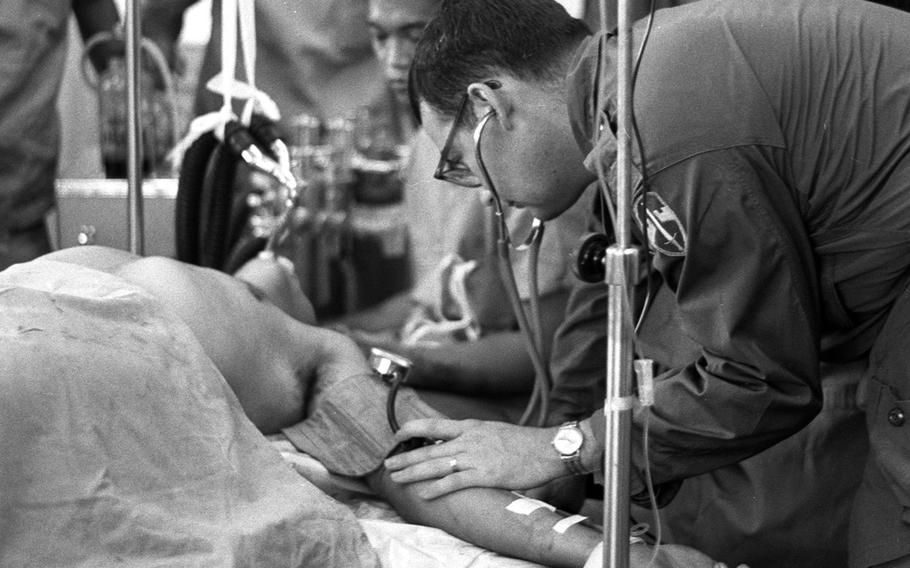 Dr. (Capt.) Richard Wurster examines a wounded U.S. Special Forces sergeant at a small field hospital in Vietnam in 1965.