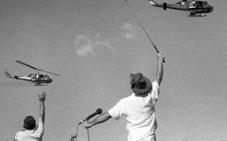December, 1965: Bob Hope â€” with his trademark golf club â€” and members of his troupe wave to passing helicopters during a show at the Bien Hoa air base.