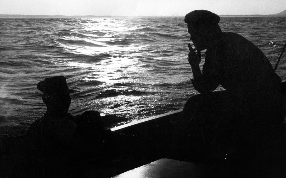 October, 1965: Lt. Harry Clock, left, and Lt. Cmdr. John Larson smoke and talk aboard a Vietnamese Navy patrol boat after a long day fighting the Viet Cong along the coast of central Vietnam. 