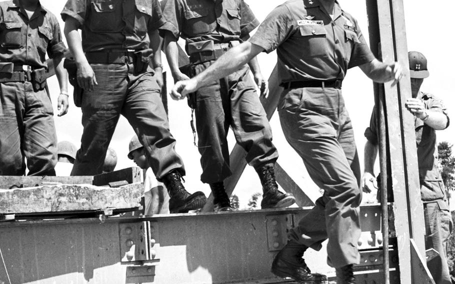 June, 1965: Gen. William Westmoreland, commander of U.S. forces in South Vietnam, jumps down from the end of a bridge being built by South Korean troops. On his tour of the area, Westmoreland also visited with Australian soldiers and Americans from the 173rd Airborne Brigade.