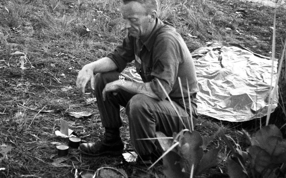 Cpl. James Thogode waits for his C rations to heat up near Plei Me, Vietnam, in November, 1965.