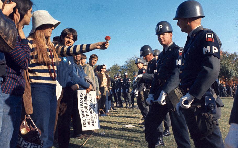 A female demonstrator offers a flower to military police on guard at the Pentagon during an anti-Vietnam demonstration on Oct. 21, 1967.