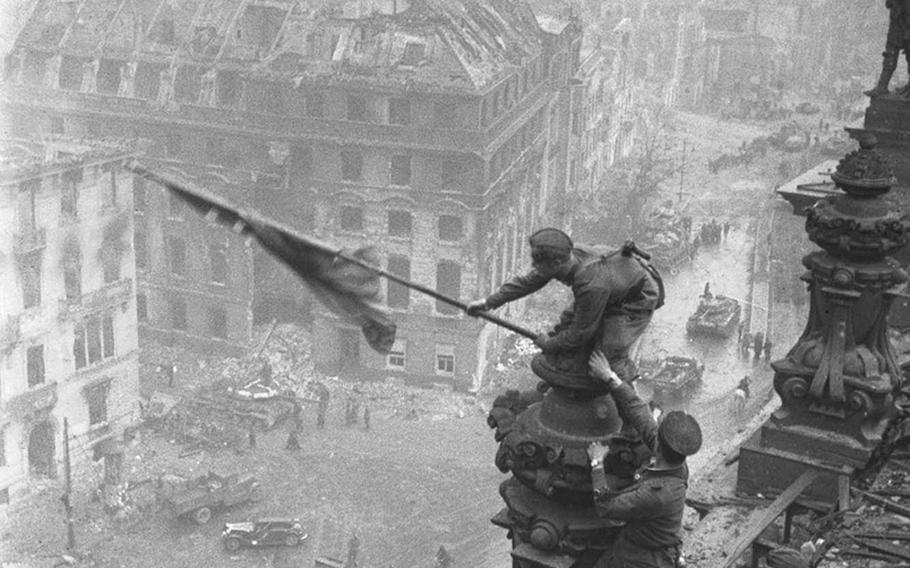 Soviet soldiers raise a red victory flag over the Reichstag in Berlin after the German capital's capture in May 1945 marking the defeat of Germany in World War II. Photographer Yevgeny Khaldei, born in 1917 in Ukraine, was famous for his pictures made during World War II, but was fired in 1948 as a part of an official discrimination campaign againsts Jews.