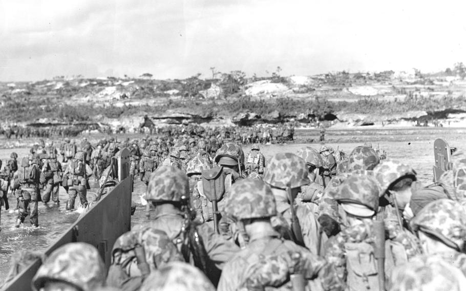 Marines wade through surf over coral reef prior to the invasion of Okinawa on March 31, 1945. 