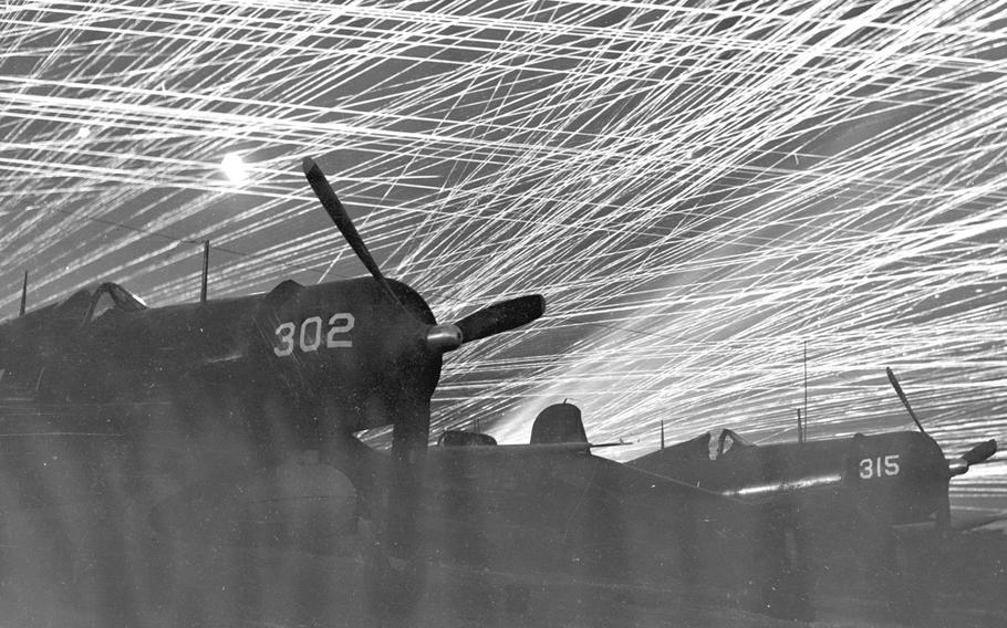 Corsairs of the ''Hell's Belles'' Marine Corps fighter squadron are silhouetted against the sky by a molten lead lacework of anti-aircraft shells on April 16, 1945, during the Battle of Okinawa. This photo was made during a Japanese air raid on Yontan airfield.