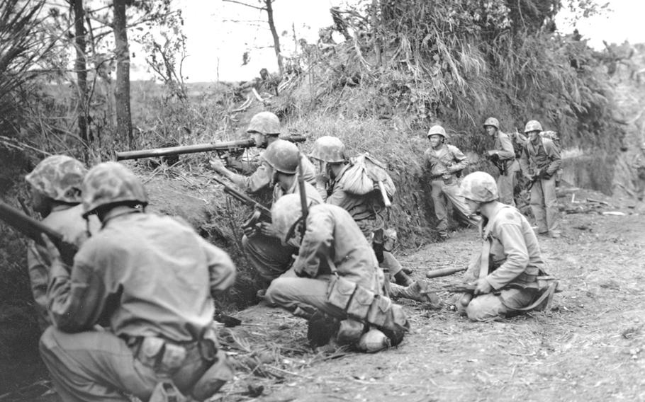 Supported by bazookas, Marines assault a ridge two miles north of Naha on May 4, 1945, during the Battle of Okinawa.