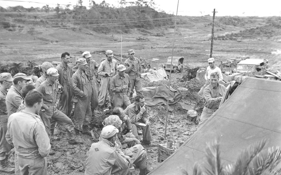 Col. Allen Shapley, 4th Marine Regiment commander, points out to his officers their objectives for the big push, on the map on May 20, 1945, during the Battle of Okinawa.