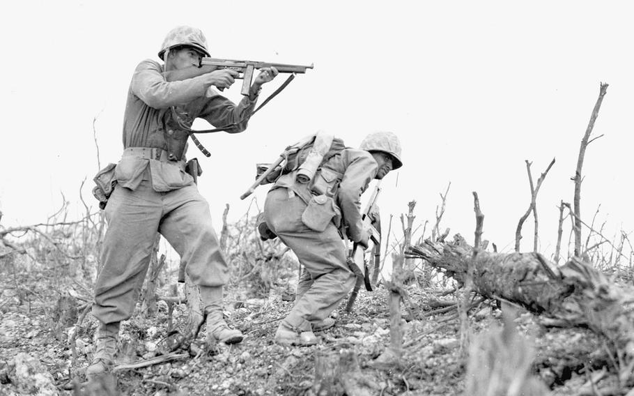 A Marine lines his sights on a Japanese sniper with his ''Tommy gun'' as his companion ducks for cover during the Battle of Okinawa. The division was engaged in taking Wana Ridge before the town of Shuri.