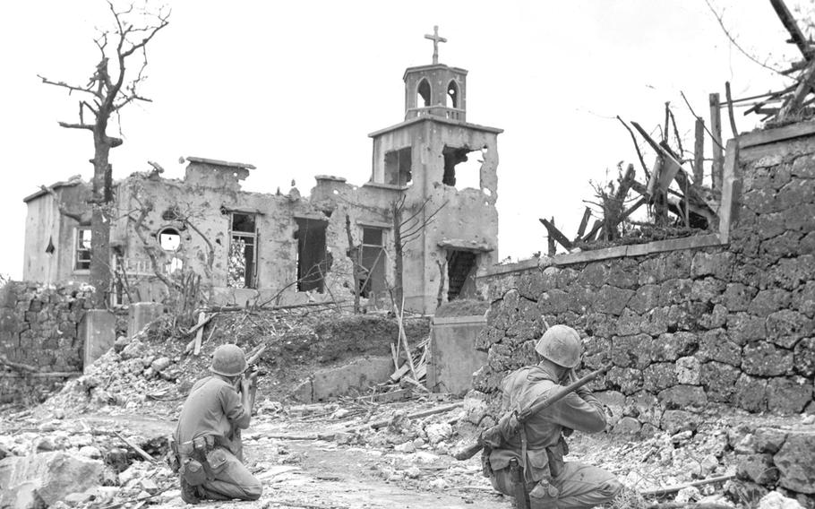 Below Shuri Castle, on Okinawa, Marines found a Christian church whose steeple provided a snipers' nest for the Japanese. The Marines in the foreground are covering the building while a patrol comes in from the rear. 