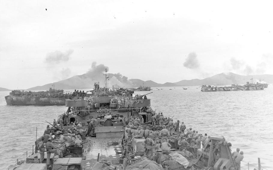 A Marine-laden landing ship moves toward Iheya, Okinawa, as the land is pounded by an air assault on June 3, 1945.