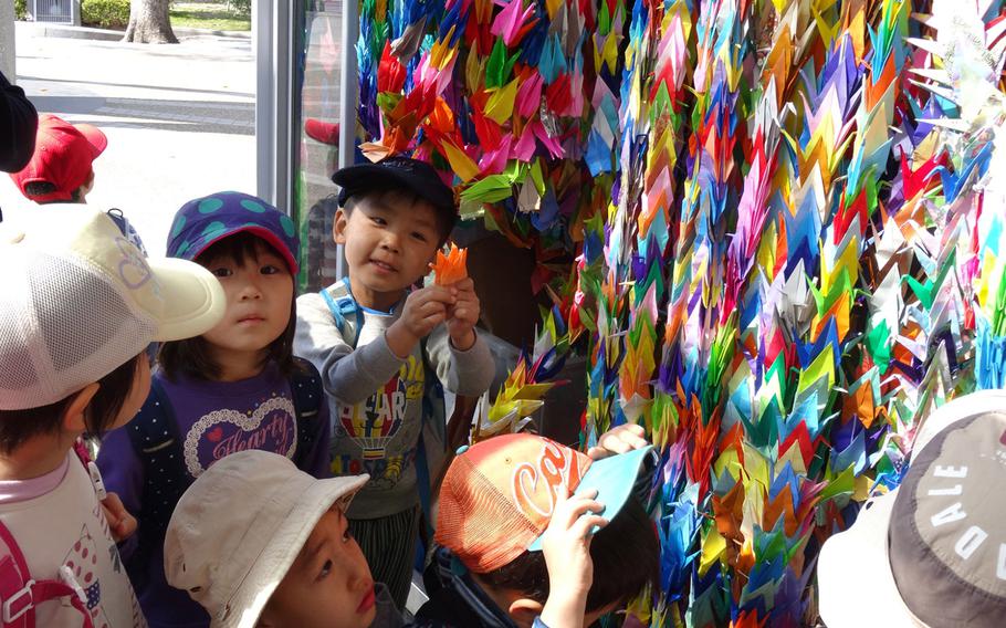 Children from a local kindergarten donate origami paper cranes they folded to the Children's Peace Monument on March 25, 2015, in Hiroshima, Japan.