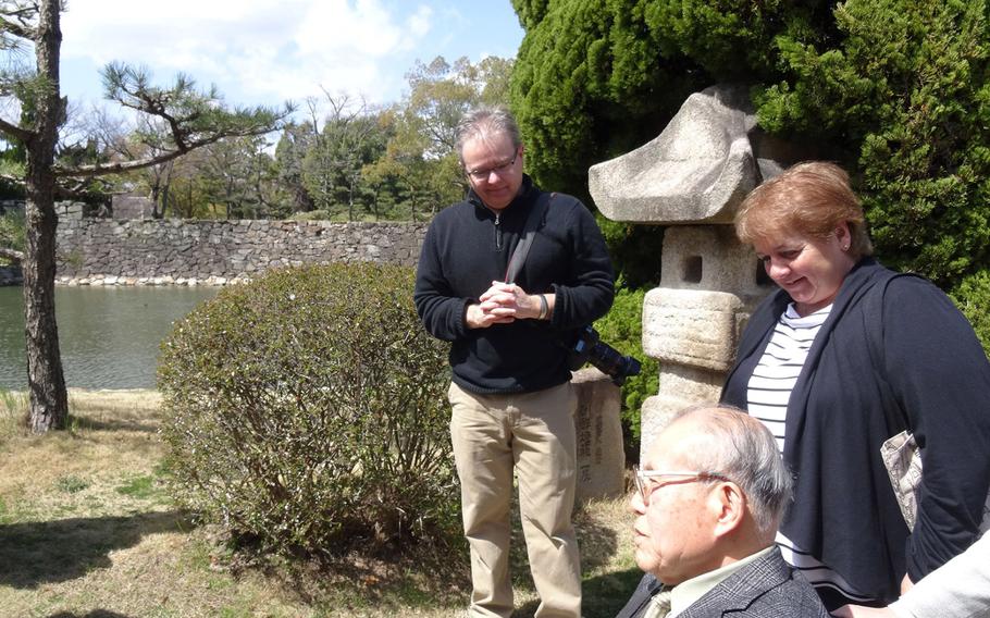 Shigeaki Mori, 77, a Hiroshima historian chats with Susan Archinski of Massachusetts as filmmaker Barry Frechette watches them near the moat of Hiroshima Castle on March 23, 2015. Archinski visited Hiroshima to follow the footsteps made 70 years ago by her uncle, Normand Brissette, who was a prisoner of war in Hiroshima and died from radiation sickness following the dropping of the atomic bomb. 