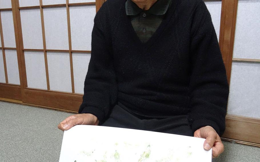 A retired calligraphy professor, Hiromu Morishita, 84, shows a picture he drew of the scenes he witnessed immediately after the atomic bomb was dropped in Hiroshima in August 6, 1945. About 80 students, including Morishita, were lining up near a bridge, which was located less than a mile from the epicenter when the bomb was detonated about 2,000 feet above the ground.