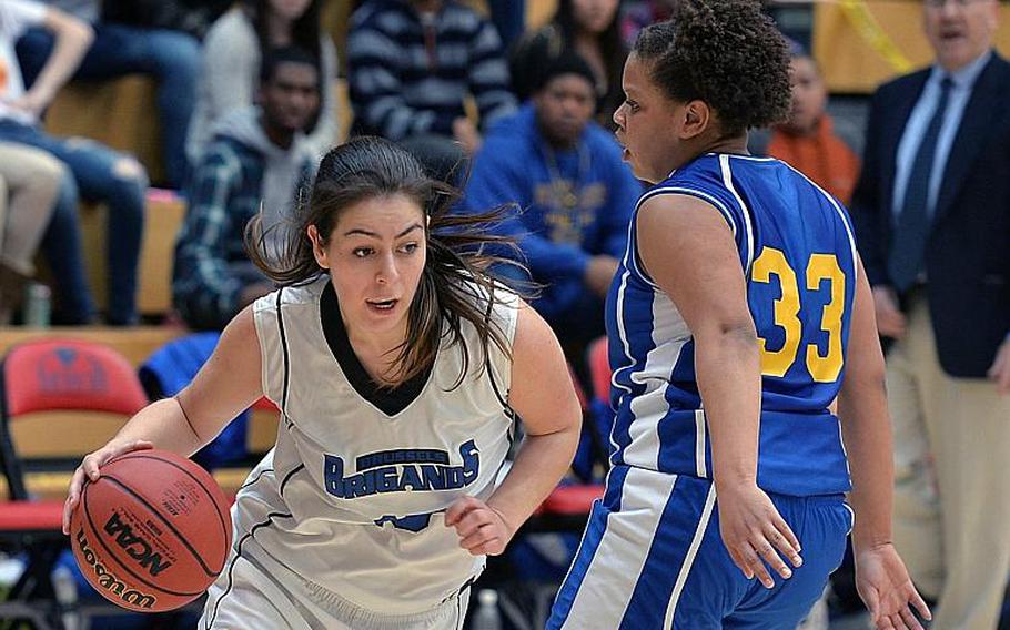 Ana-Marija Vasileva of Brussels drives against Sigonella's Sydney Moore in the Division III girls final at the DODDS-Europe basketball championships in Wiesbaden, Germany, Feb. 22, 2014. Brussels won 38-31 in overtime.