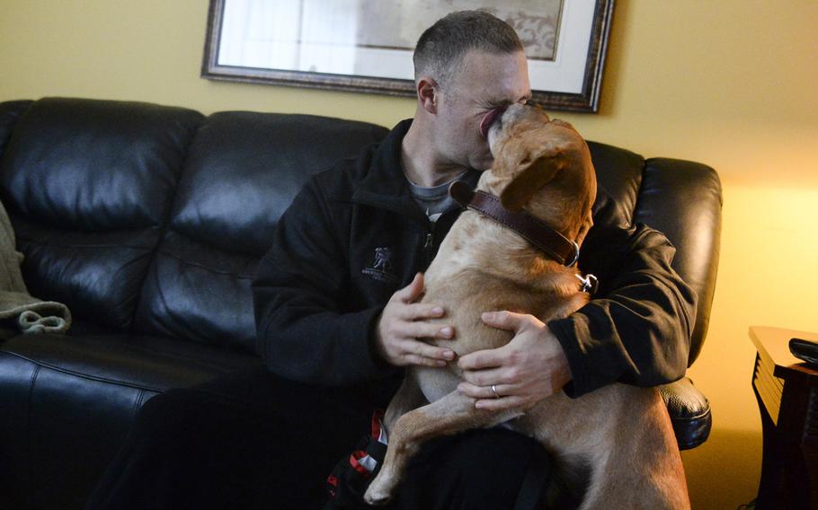 Corky shows his affection for Sgt. Eric Goldenthal  Jan. 27, 2014, at Landstuhl Regional Medical Center in Germany. They both received gunshot wounds to the leg while deployed to Afghanistan.
