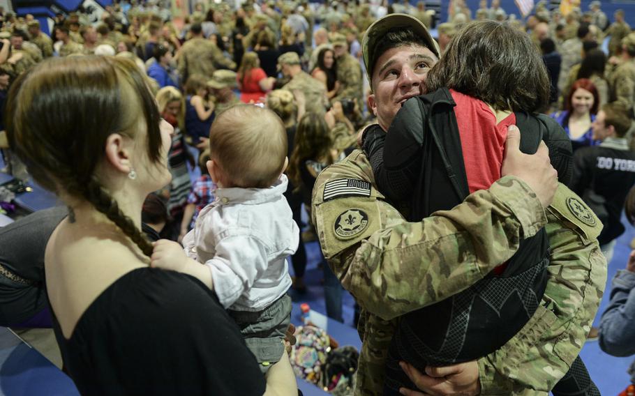 Pfc. Jeremy Monteleone holds daughter Jaden as his wife, Tiana Musson, and his son, Emrick Monteleone, wait their turn for hugs. The soldier was reunited with his family April 8, 2014, after a seven-month deployment to Afghanistan.