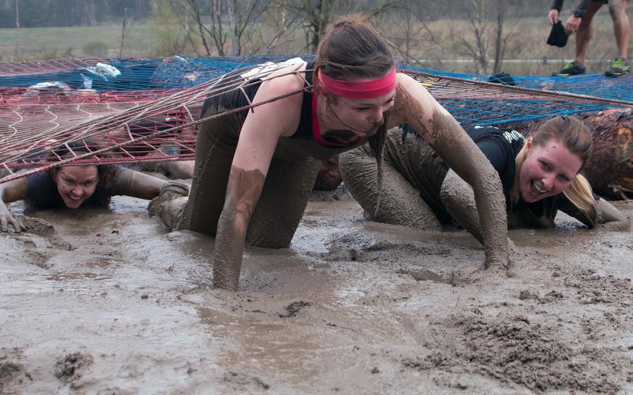 Participants crawl through mud at the second annual Grafenw?hr Rugged Terrain Obstacle Course, April 12, 2014. The event began at the base gym but wound through 13 kilometers of wooded terrain, dotted with more than a dozen obstacles.