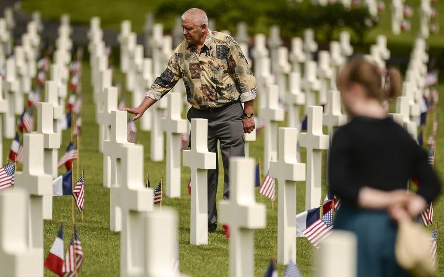 Kielar Hubert, an observer at the Memorial Day ceremony at Lorraine American Cemetery, touches a grave after the ceremony May 25, 2014, at St.-Avold, France.