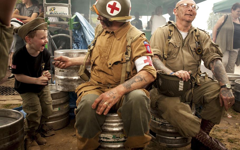 Re-enactors play around behind a beer tent on June 8, 2014, in Sainte-M?re-?glise after a parade of American, French and German soldiers marched into town as part of the 2014 D-Day commemorations in Normandy.