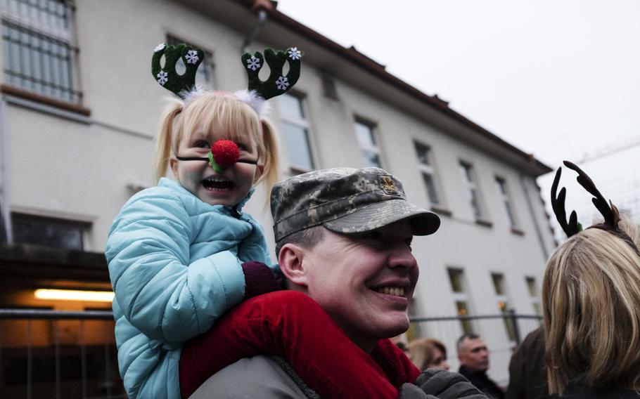 Reilly Neimhaus, 3, sits on the shoulders of her father, Maj. Pete Neimhaus, for a better view of the 21st Theater Sustainment Command's fifth annual tree lighting ceremony at Panzer Kaserne, Germany, Dec. 4, 2014.