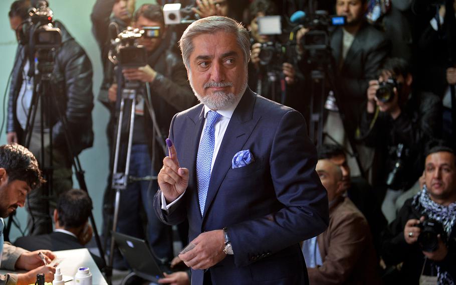 Afghan presidential candidate Abdullah Abdullah displays his ink-stained finger before voting  on April 5, 2014.